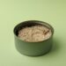 Tin with canned tuna on green background
