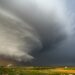 A tornado-producing supercell thunderstorm spinning over ranch land at sunset near Leoti, Kansas